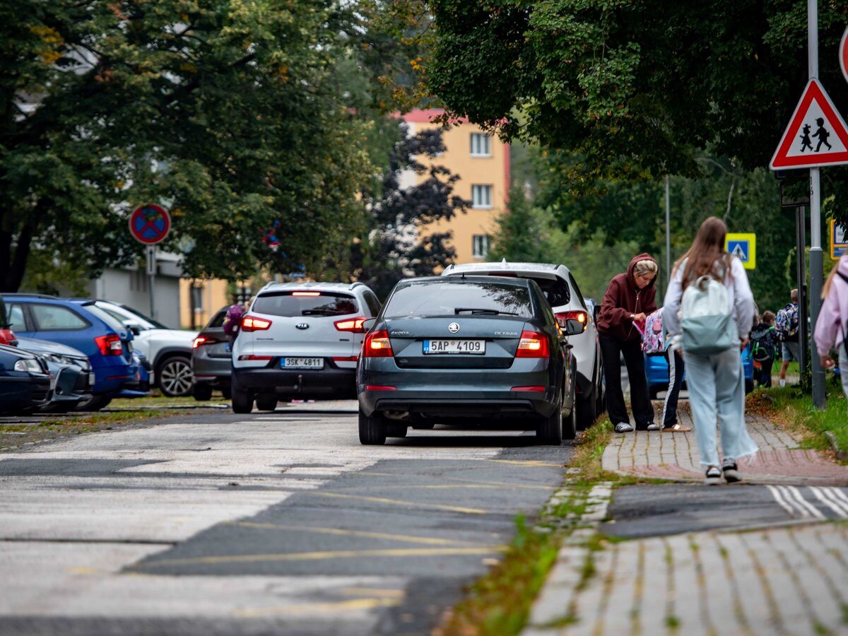 Auta parkují také na autobusové zastávce před budovou nižšího stupně.
